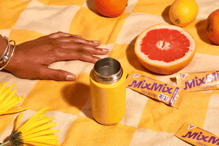 MixMix Citrus THC drink mix being poured and shaken into a refreshing citrus beverage