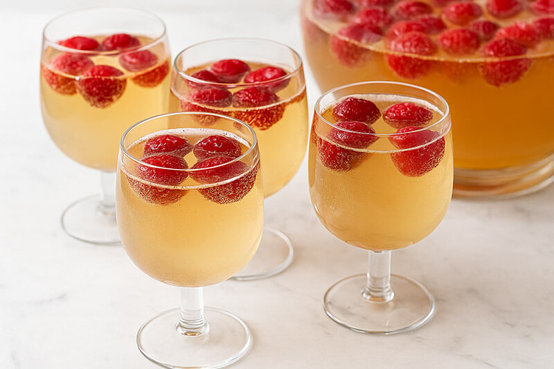 Glasses of punch with raspberries on a marble surface